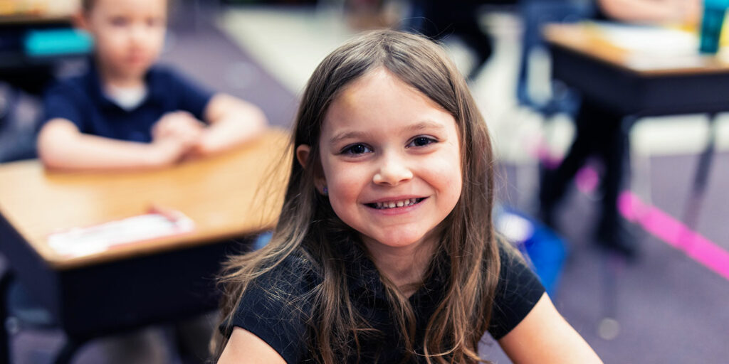 Smiling student in classroom.